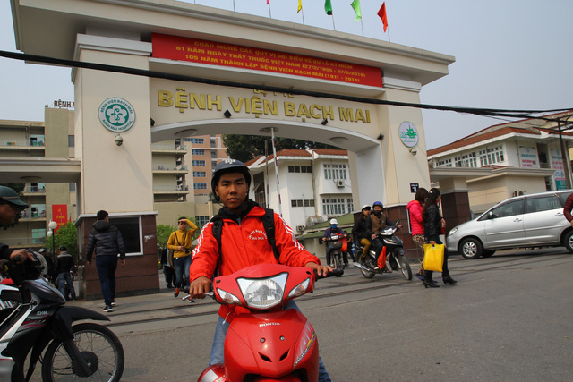 Phan Ngọc Quý và chiếc xe wave chuẩn bị đón khách trước cổng Bệnh viện Bạch Mai. Ảnh: LN