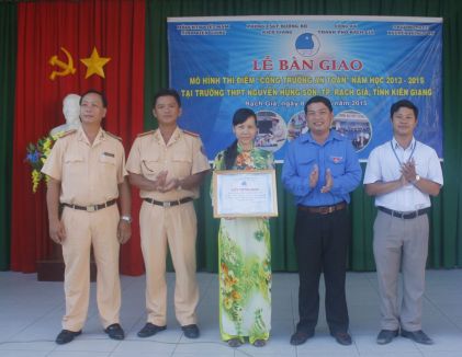  Đồng chí Lê Trung Hồ trao giấy chứng nhận mô hình “Cổng trường an toàn giao thông” cho đại diện Trường Trung học phổ thông Nguyễn Hùng Sơn.