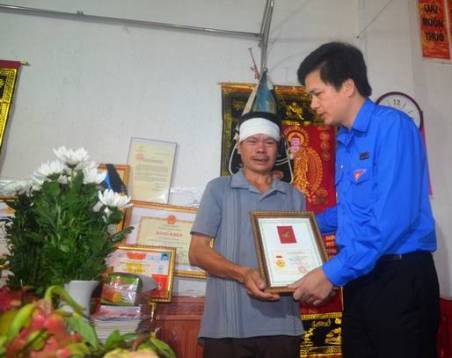 Ông Nguyễn Văn Điều (Bố của Đ/c Nam) đã thay mặt gia đình nhận huy hiệu