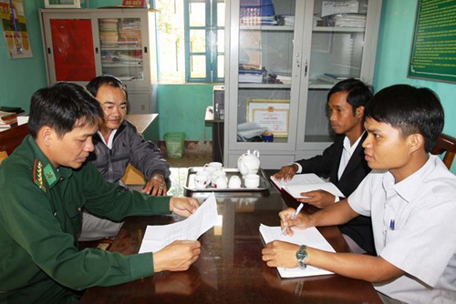 Hồ Văn Ngoai (bìa phải) thảo luận với cán bộ cốt cán xã A Dơi - Ảnh: N.P
