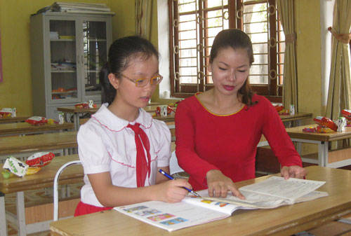 Em Trần Ngọc Linh, học sinh lớp 4B, Trường Tiểu học Trưng Vương đang hỏi bài cô giáo chủ nhiệm.