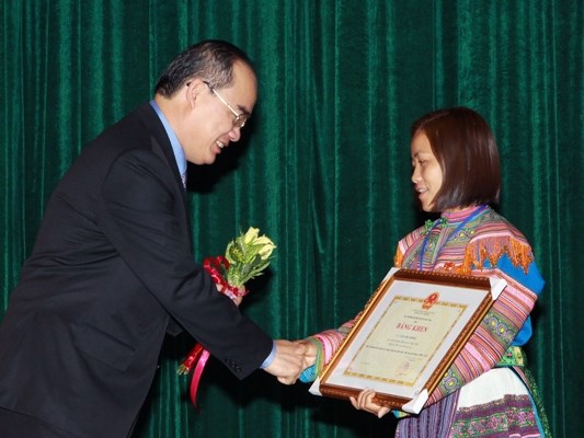 Đồng chí Nguyễn Thiện Nhân, Ủy viên Bộ Chính trị, Chủ tịch Ủy ban TƯMTTQ Việt Nam tặng hoa chúc mừng cô Ghếnh.