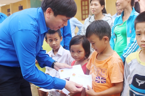 Đồng chí Nguyễn Long Hải – Bí thư Trung ương Đoàn, Chủ tịch Hội đồng Đội Trung ương trao quà cho các em học sinh có hoàn cảnh khó khăn tại huyện Hương Khê, Hà Tĩnh.