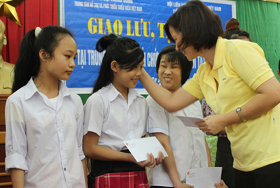 Chị Hoàng Tú Anh, Phó Chủ tịch Thường trực Hội đồng Đội Trung ương, Giám đốc Trung tâm Hỗ trợ và Phát triển Thiếu nhi Việt Nam trao học bổng Thánh Gióng cho trẻ em khuyết tật.