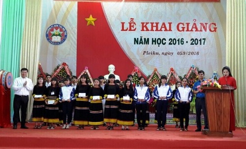 Đồng chí Lê Quốc Phong (áo trắng bên trái) trao học bổng cho các em học sinh ặp nhiều khó khăn vươn lên học giỏi 