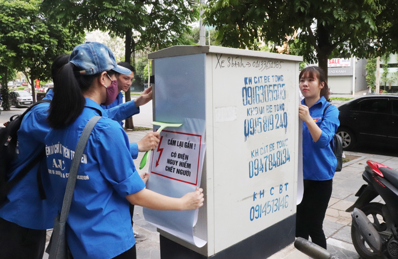Thanh niên Thủ đô dán đề can tuyên truyền trên các tủ điện, bốt điện sau lễ ra quân chiến dịch