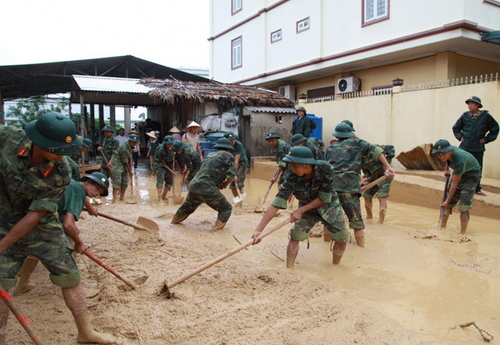 ĐVTN quân đội giúp đỡ nhân dân dọp dẹp bùn đất, dựng lại nhà cửa