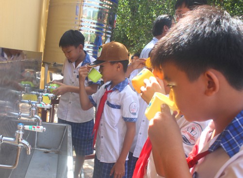 Các em học sinh uống nước từ hệ thống mới ngay sau buổi bàn giao