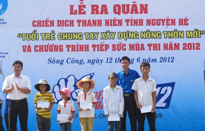 Đ/c Tạ Văn Hạ - Tổng chỉ huy trưởng lực lượng TNXP TW (bìa trái) và Đ/c Dương Văn Tiến - Bí thư Tỉnh Đoàn trao quà cho các em học sinh nghèo vượt khó 