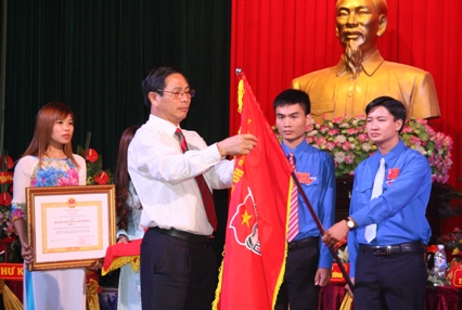 Đồng chí Lê Văn Tân gắn huy chương lao động hạng 3 lên lá cờ Đoàn