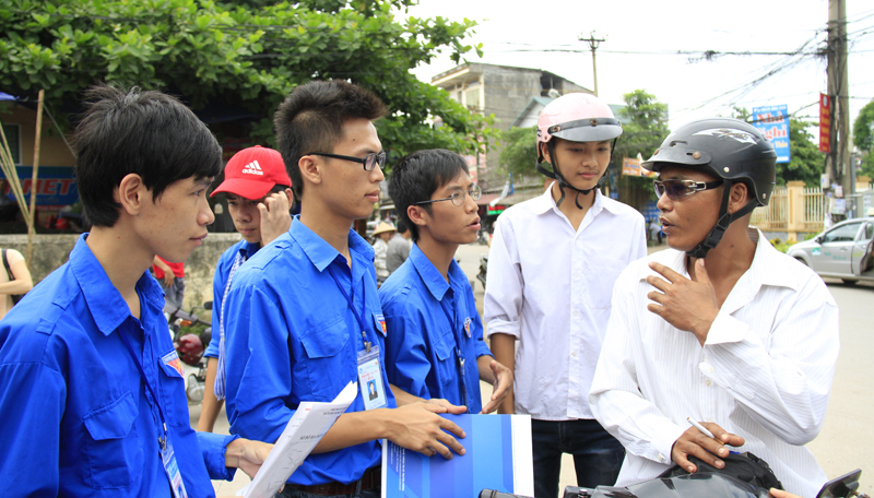 Sinh viên tình nguyện tư vấn cho sĩ tử và người nhà trước cổng trường ĐH Công nghệ thông tin và truyền thông