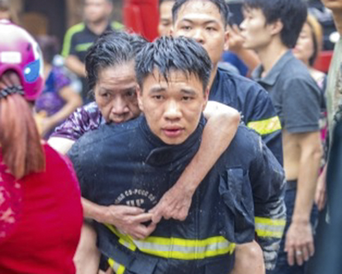 Trung sỹ Mạnh cõng bà Thạch thoát khỏi ngôi nhà bị cháy (ảnh chụp ngày 13-5-2017).