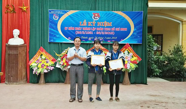 Ban giám hiệu trường THPT Yên Thành 2 trao giấy khen biểu dương hai nữ sinh trước toàn trường vì nhặt được trả lại cho người đánh mất - Ảnh: DANH HÙNG
