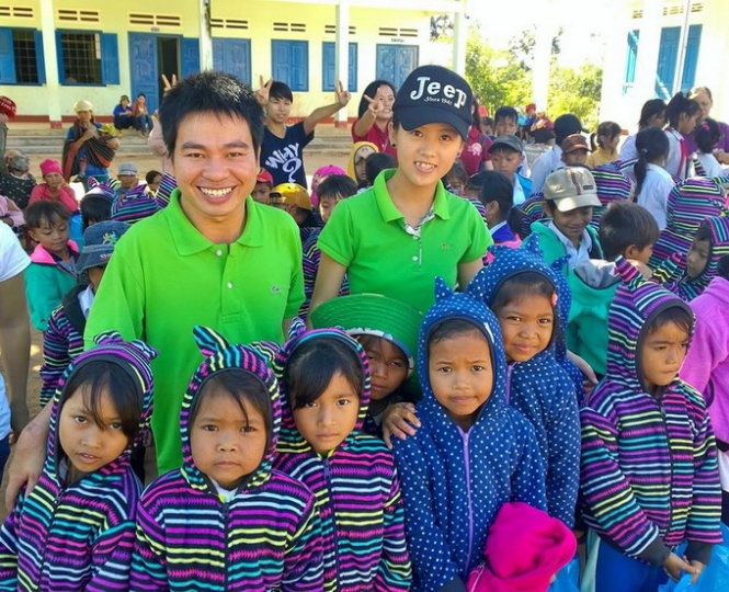 Nguyễn Duy Học (trái) cùng các em học sinh sau khi nhận áo ấm, quà do nhóm trao tặng - Ảnh: Nhóm Vòng tay yêu thương cung cấp