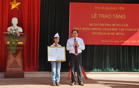  Thừa uỷ quyền của Chủ tịch nước, đồng chí Trần Tiến Dũng, Phó Chủ tịch UBND TX Quảng Yên trao tặng Huân chương Dũng cảm cho em Phạm Quốc Hùng .