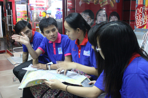 Vũ Linh (thứ hai từ trái qua) đang cùng nhóm sinh viên tình nguyện phân chia công tác tiếp sức mùa thi tại ga Sài Gòn. Ảnh: TT.