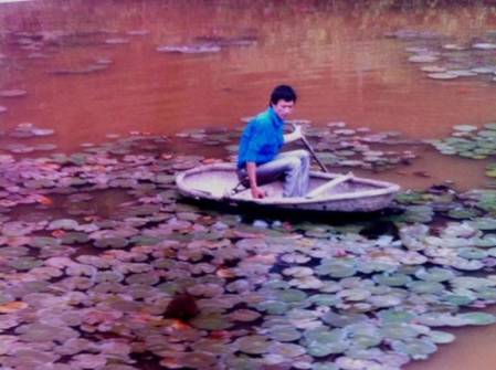 Trần Văn Tuấn bơi thuyền kiểm tra tình hình dịch bệnh ở hồ cá