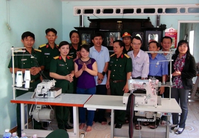 Phòng Chính trị Bộ CHQS tỉnh Bình Định và Ban chỉ đạo giảm nghèo địa phương bàn giao máy vắt sổ và máy may tặng chị Lê Thị Thúy Vân, ở phường Quang Trung, TP Quy Nhơn.