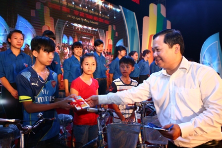 Đồng chí Nguyễn Phi Long, Bí thư Trung ương Đoàn, Chủ tịch Hội LHTN Việt Nam tặng quà cho các em học sinh tại chương trình