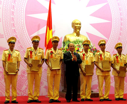 Chủ tịch Quốc hội Nguyễn Sinh Hùng tặng quà các thanh niên công an tiên tiến.