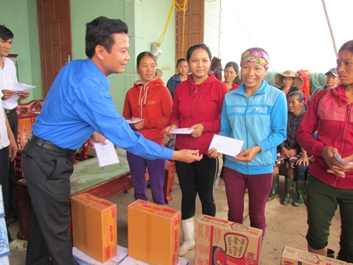 Đồng chí Trần Quốc Tuấn - Bí thư Tỉnh Đoàn Quảng Bình trao quà cho bà con nhân dân vùng lũ