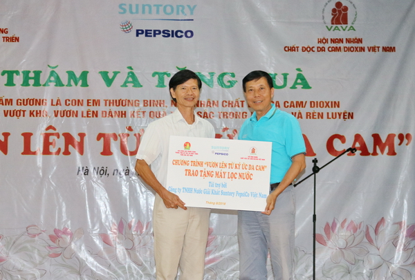 Đại diện Công ty TNHH Nước giải khát Suntory PepsiCo Việt Nam trao tặng máy lọc nước cho Trung tâm