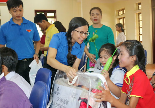 Đồng chí Nguyễn Phạm Duy Trang hỏi thăm thành tích học tập và tặng quà các em thiếu nhi