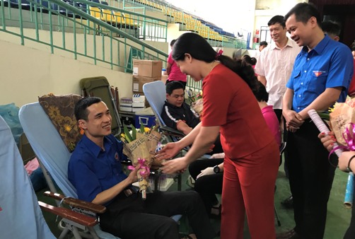 Đ/c Đỗ Thị Minh Hoa - Phó Chủ tịch UBND tỉnh và đ/c Nông Bình Cương - Bí thư Tỉnh đoàn tặng hoa cho ĐVTN tham gia hiến máu tại Ngày hội
