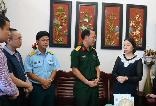 Thượng tá Đinh Quốc Hùng - Trưởng ban Thanh niên Quân đội chi buồn và động viên chị Thu Lan - vợ của phi công Lê Kiêm Toàn