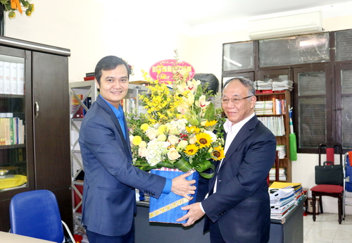 Đồng chí Bùi Quang Huy - Bí thư Trung ương Đoàn tặng hoa chúc mừng GS Hoàng Chí Bảo