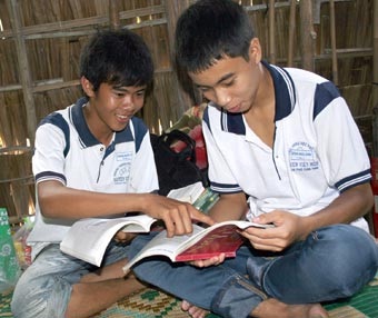 Em Chung Quốc Bảo (bên trái) trao đổi bài với bạn bè.  