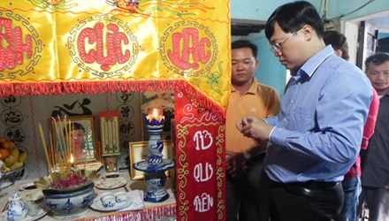 Đồng chí Lê Quốc Phong, Bí thư Trung Ương Đoàn, Chủ tịch Hội Sinh viên Việt Nam gắn huy hiệu “Tuổi trẻ dũng cảm” lên bàn thờ của anh Bửu.