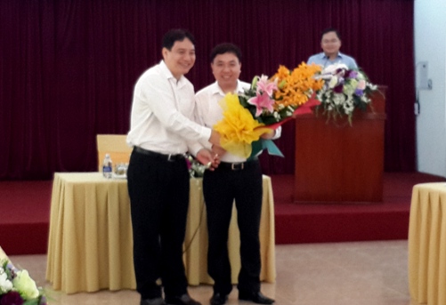 Đồng chí Nguyễn Đắc Vinh (bìa trái) tặng hoa chúc mừng đồng chí Nguyễn Mạnh Dũng