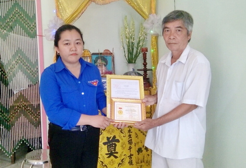 Đồng chí Lâm Như Quỳnh - Phó Bí thư Tỉnh đoàn trao Huy hiệu "Tuổi trẻ dũng cảm" cho đại diện gia đình