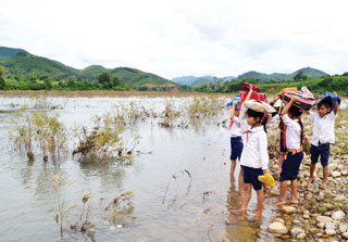  Các em học sinh H’re ở huyện miền núi Ba Tơ (Quảng Ngãi) lội sông tới trường - Ảnh: Hiển Cừ