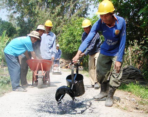 Trung và các đồng nghiệp trong tổ từ thiện của phường Tân Lộc vá đường. Ảnh: An Thuyên